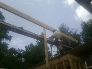 Carpenter setting a ridge beam over a new addition frame — Ice Dam Removal by Roofing Brothers in North Lewisburg