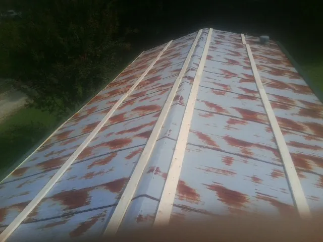 Rusted metal roof panels with new wood purlins before replacement — Storm Damage Roof Repair in North Lewisburg by Roofing Brothers