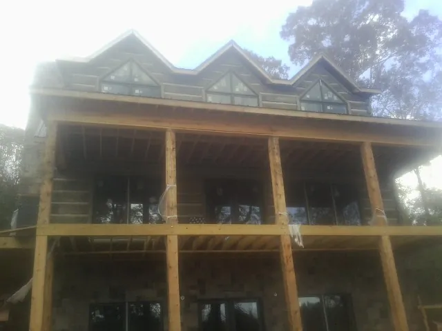 Dormers and porch framing on a large log home under construction — Roof Coating work by our crew in North Lewisburg
