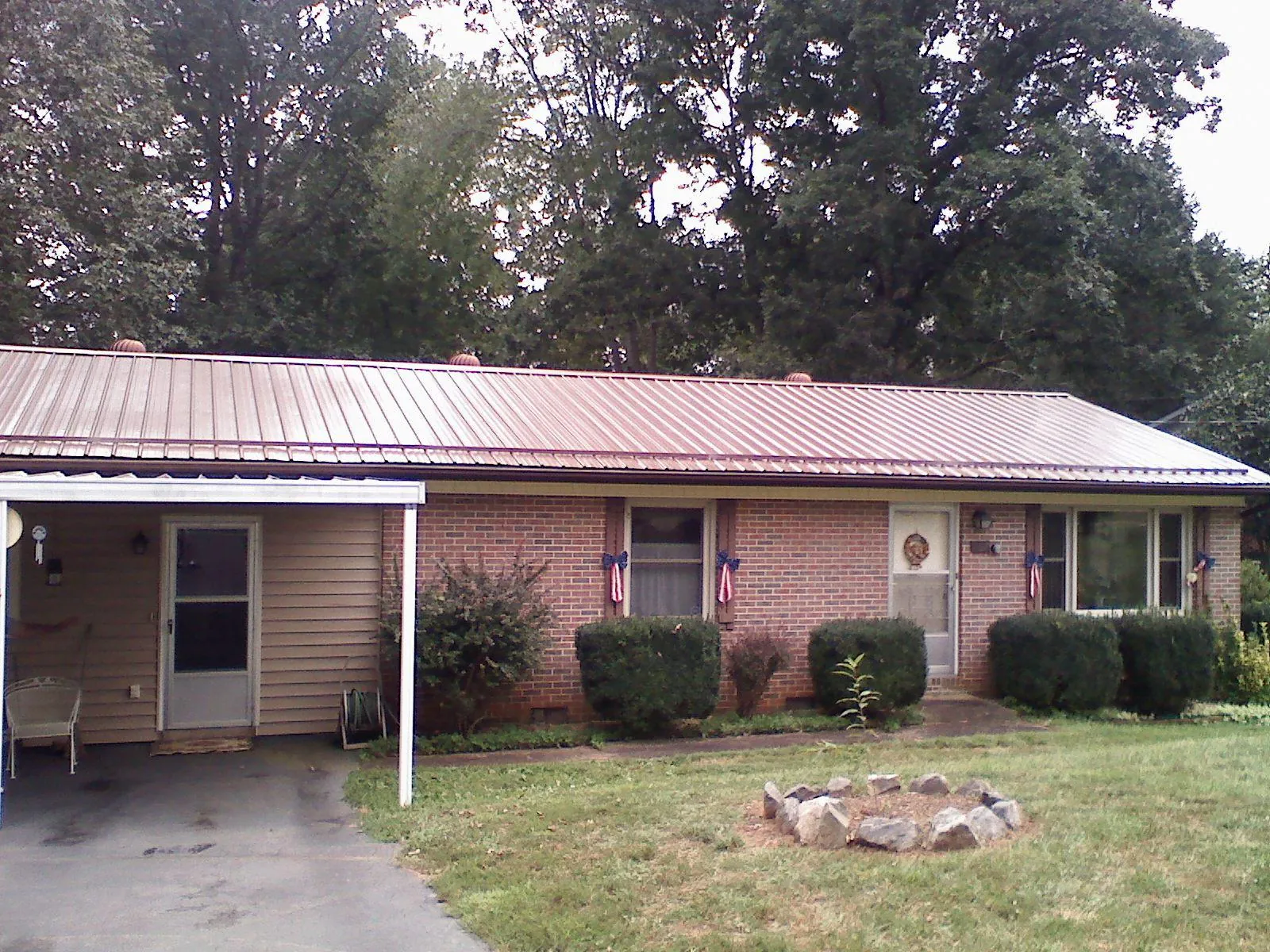 Bronze metal roof and carport on a brick ranch home — Roof Repair work by our crew in North Lewisburg